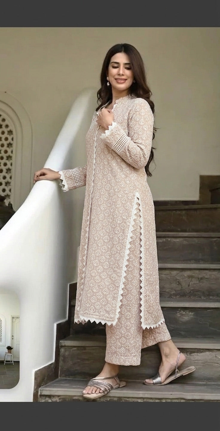 Woman in a beige traditional outfit standing on a staircase.