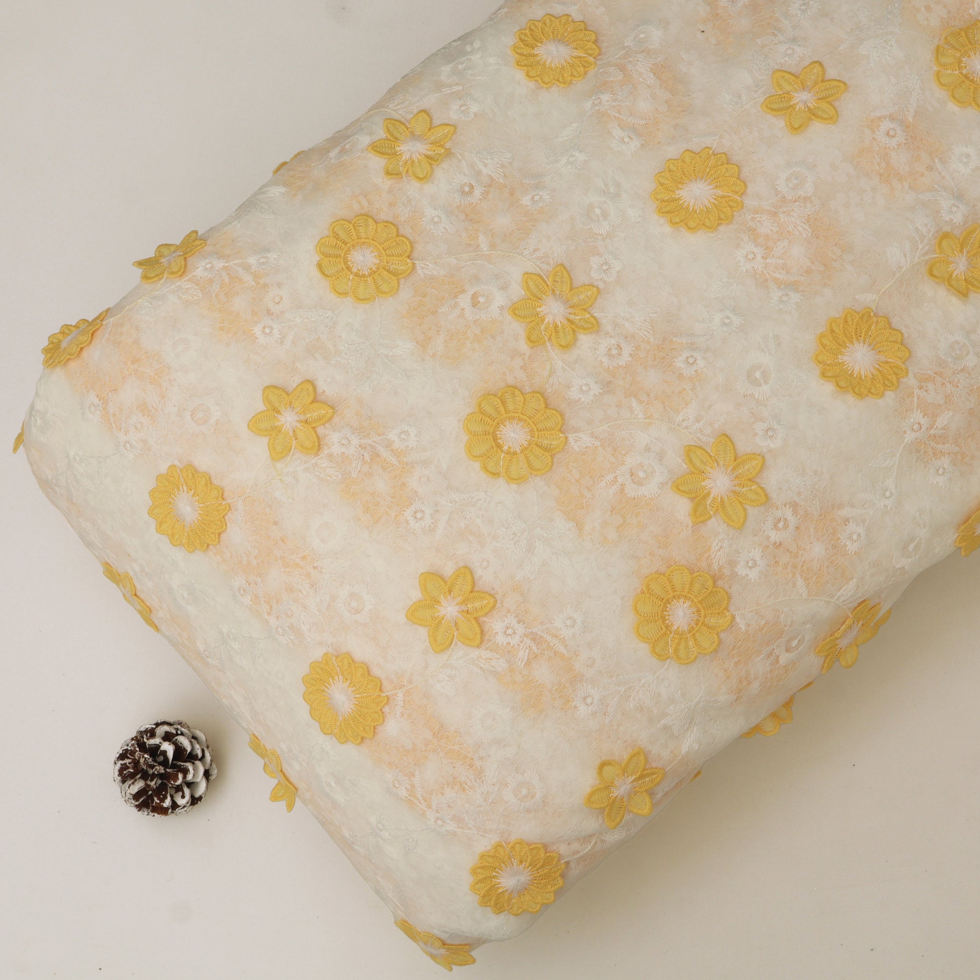Floral-patterned pillow with yellow flowers on a white background