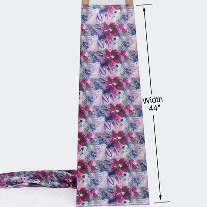 A floral apron with a multicolor watercolor-style print of pink, purple, and blue flowers on a light background, shown hanging flat with a tail extending to the left. Black dimension lines indicate a width of 44 inches.