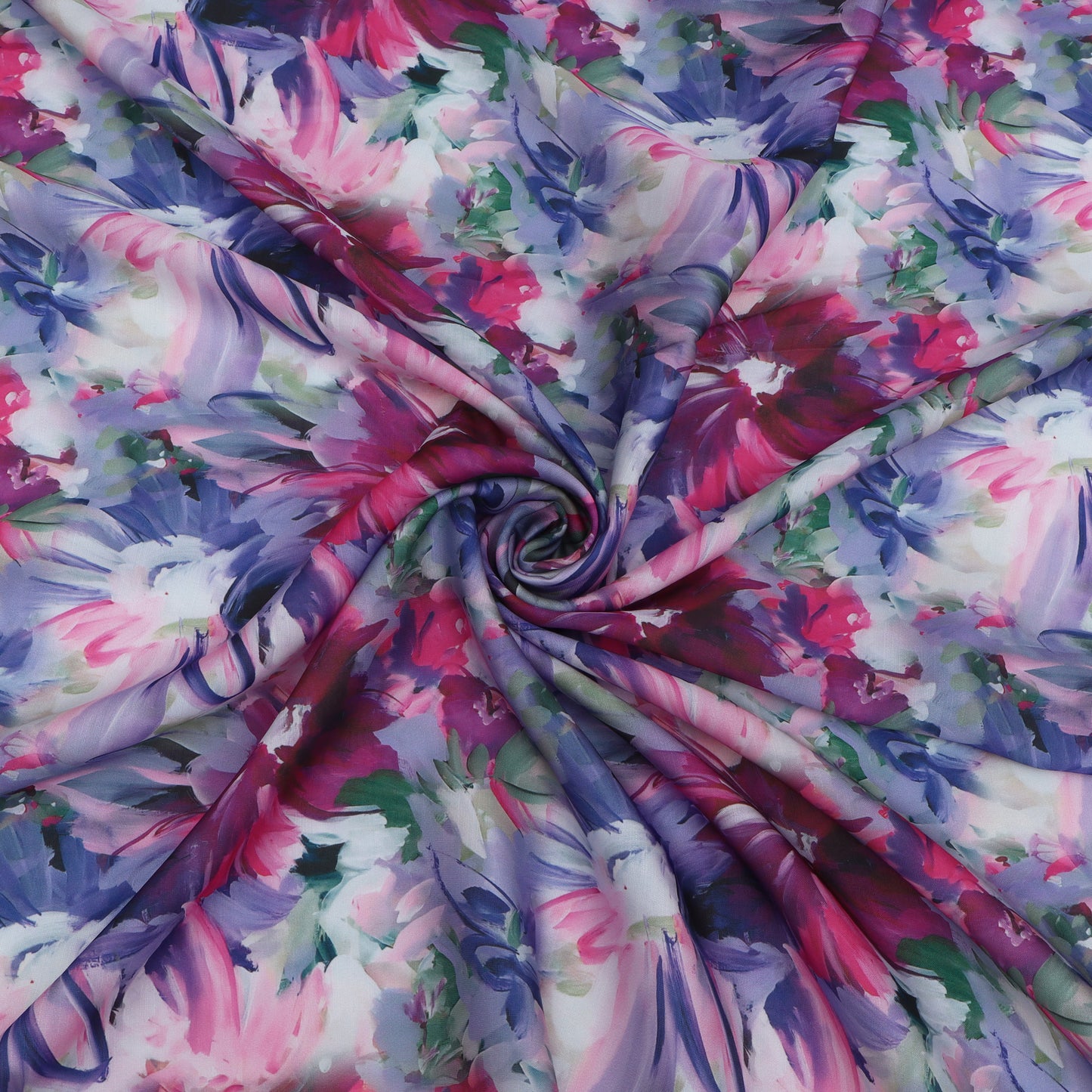 A close-up of a lightweight fabric draped in a spiral pattern, featuring a vibrant watercolor floral print in shades of pink, purple, blue, and green on a white base.