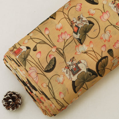 A folded piece of beige fabric with a traditional Chinese print of lotus flowers, lily pads, and figures in boats, displayed next to a small pinecone on a light background.