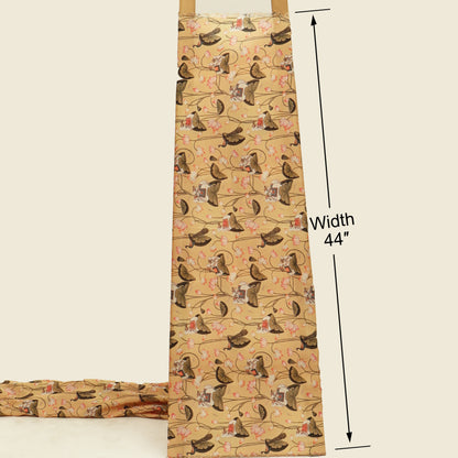 A beige apron with a repeating pattern of brown dogs on a floral vine background, shown with a folded matching apron at the bottom left and black measurement lines indicating a width of 44 inches.