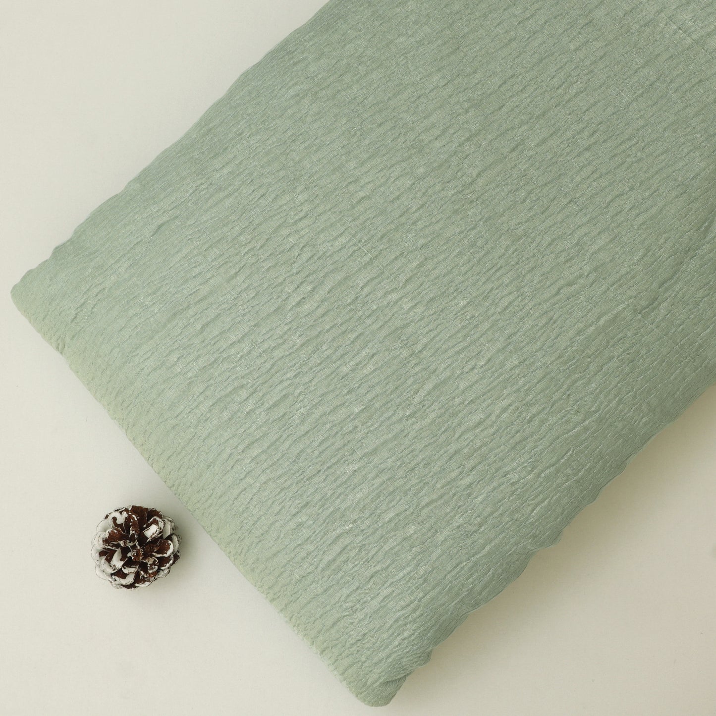 Green textured pillow on a light beige background