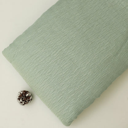Green textured pillow on a light beige background
