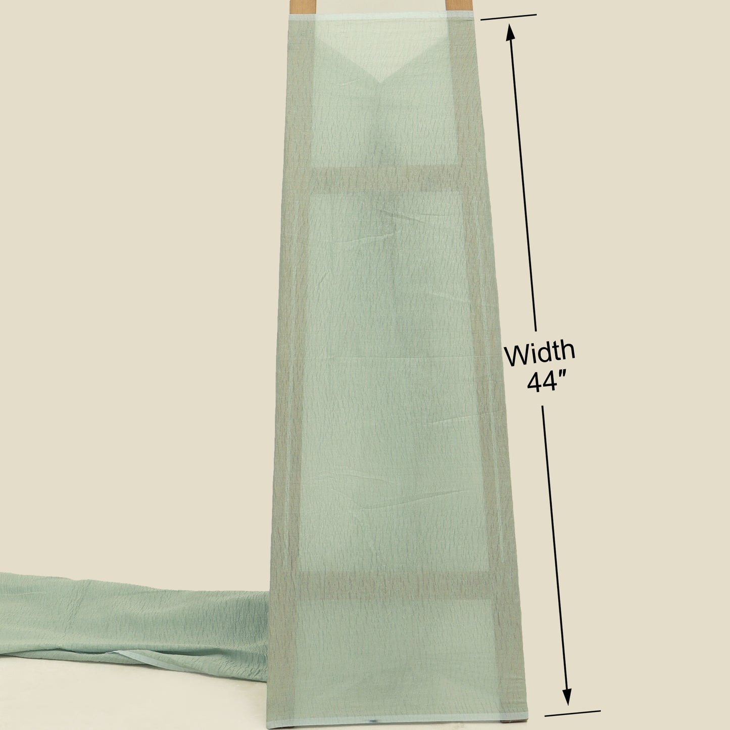 Light green fabric with a width measurement of 44 inches on a beige background
