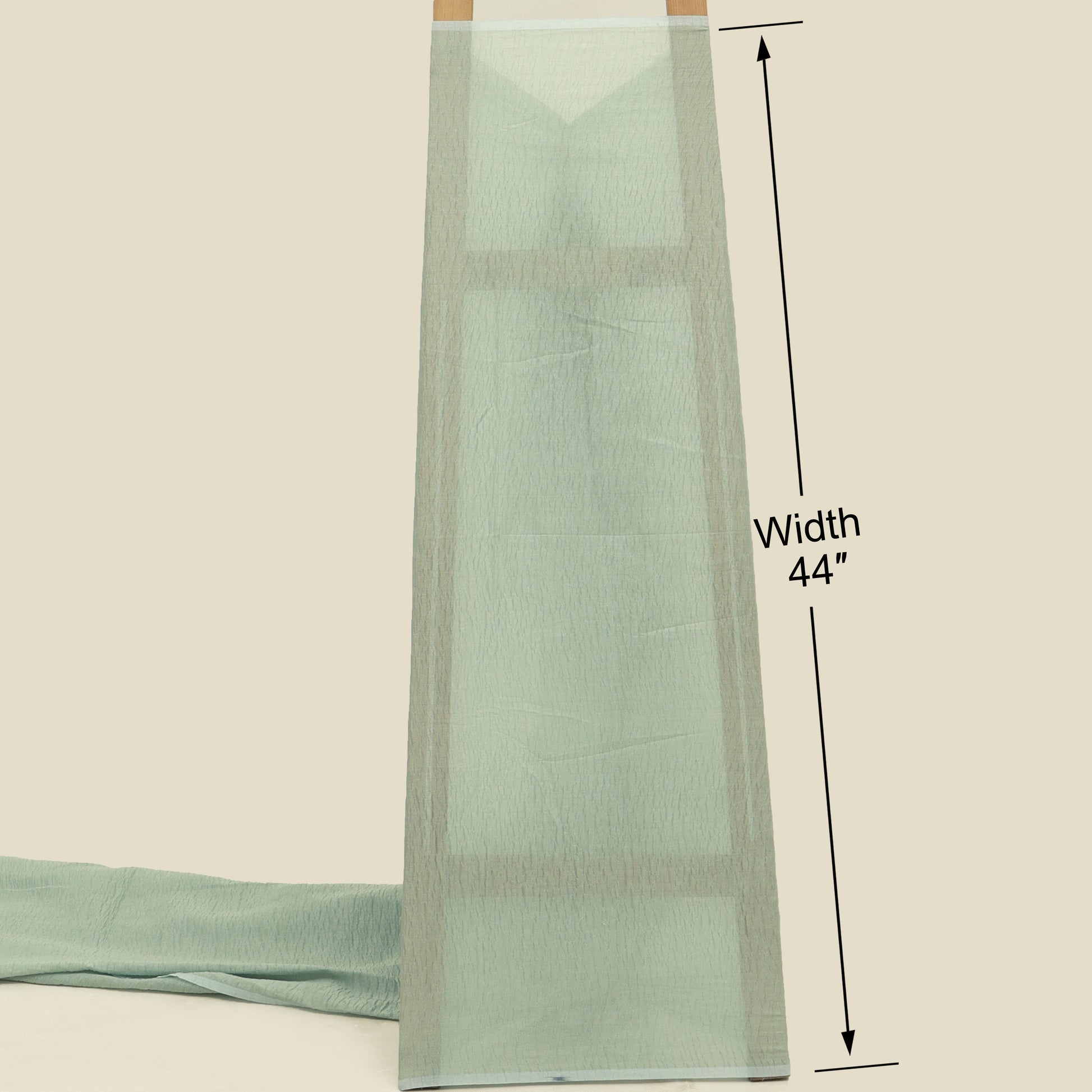 Light green fabric with a width measurement of 44 inches on a beige background