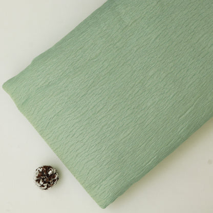 Green textured pillow on a light background