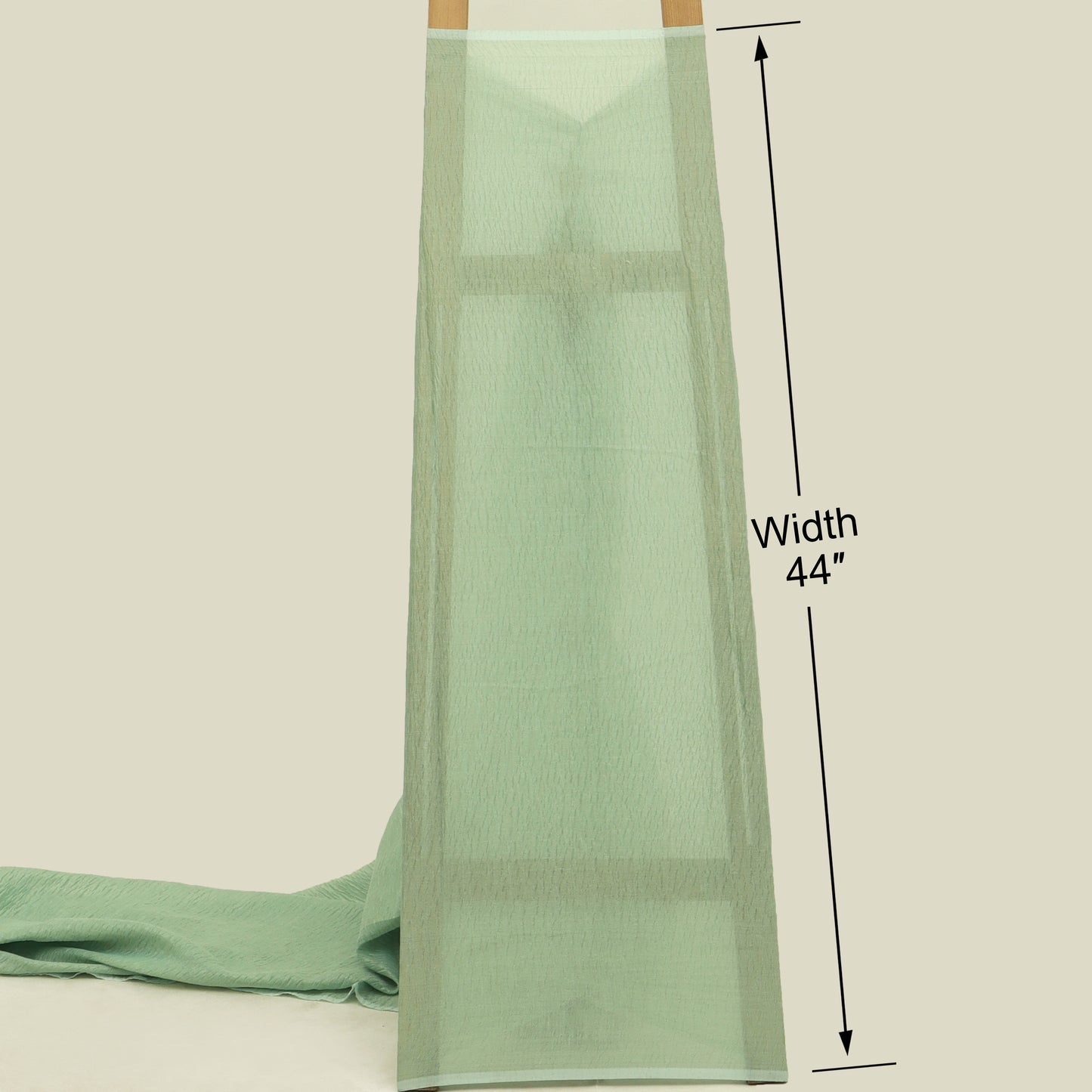 Green fabric with a measurement label indicating width 44 inches on a beige background