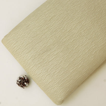 Beige textured fabric roll with a pine cone on a white background