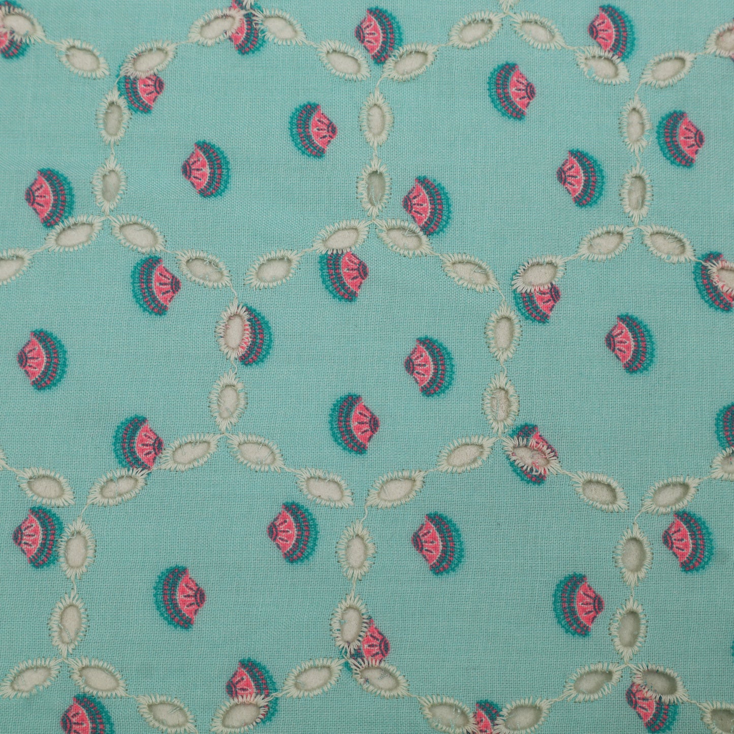 Patterned fabric with pink and green design on a teal background