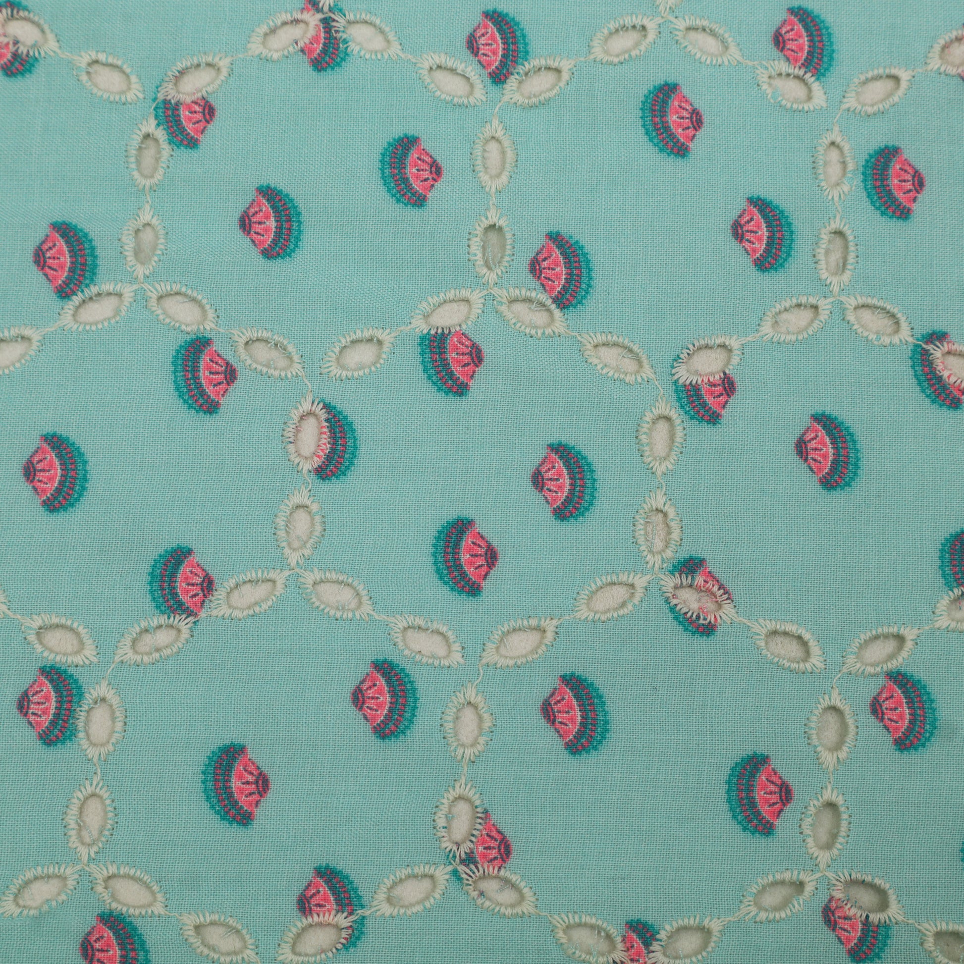 Patterned fabric with pink and green design on a teal background
