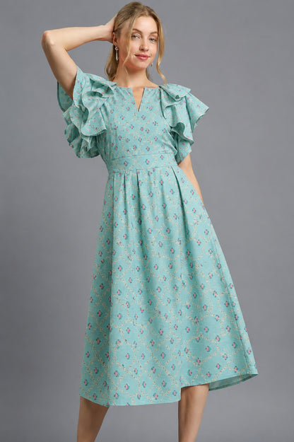 Woman wearing a teal floral dress against a gray background