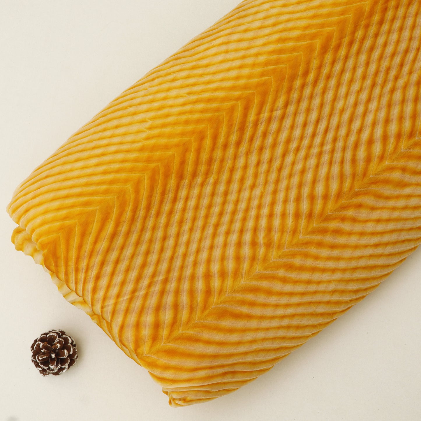 Folded yellow fabric with a textured pattern on a white background