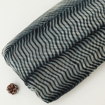 Folded fabric with wavy pattern on a white background