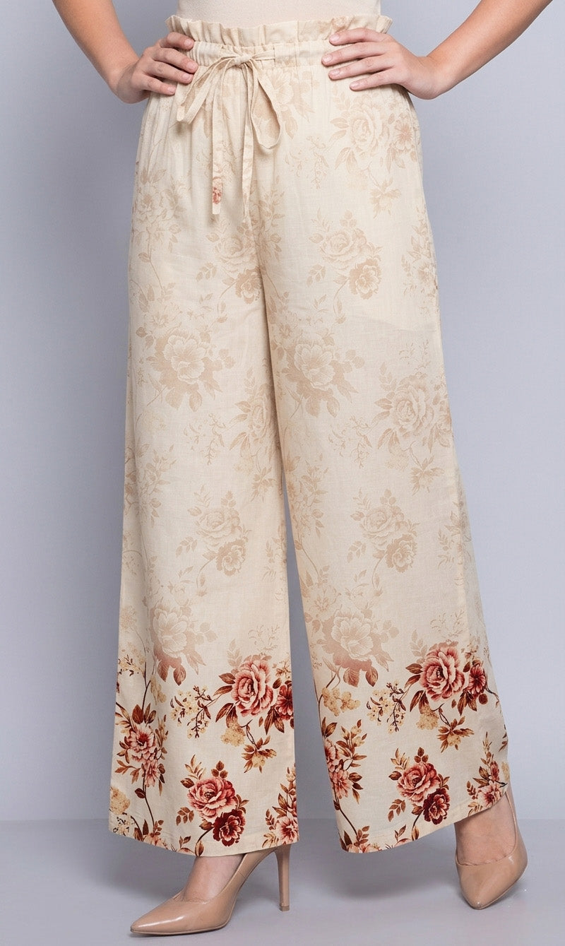 Floral patterned pants worn by a person on a gray background