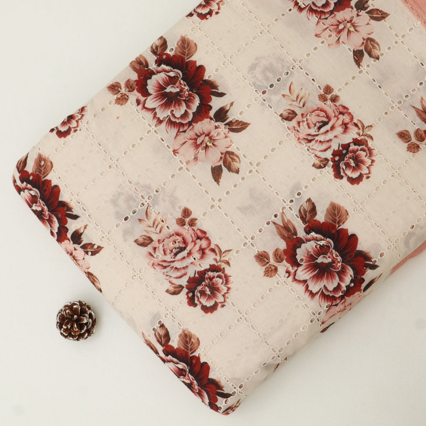 Floral-patterned fabric with a small pine cone on a white background