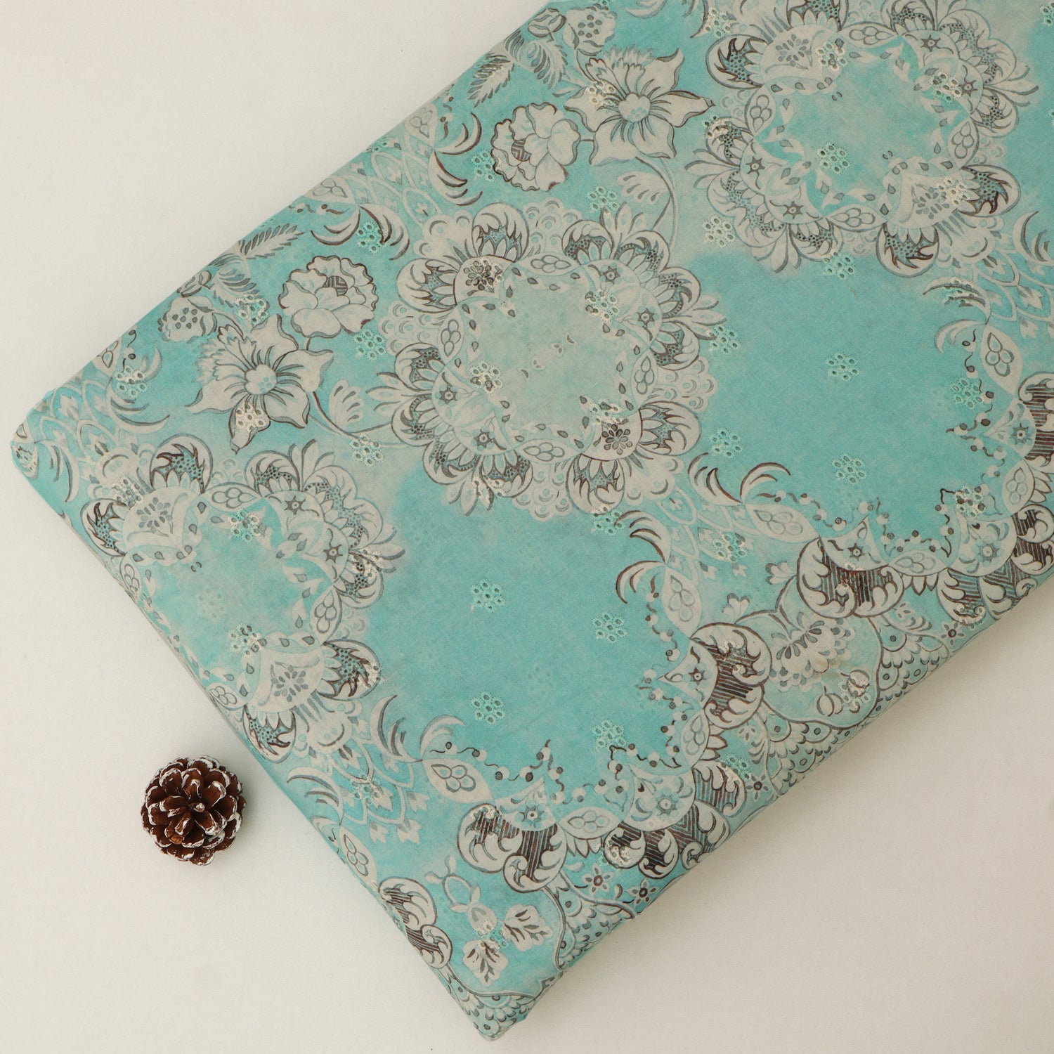 Turquoise fabric with floral pattern on a white background