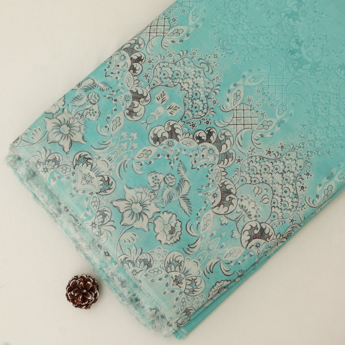 Turquoise fabric with floral and paisley pattern on a white background