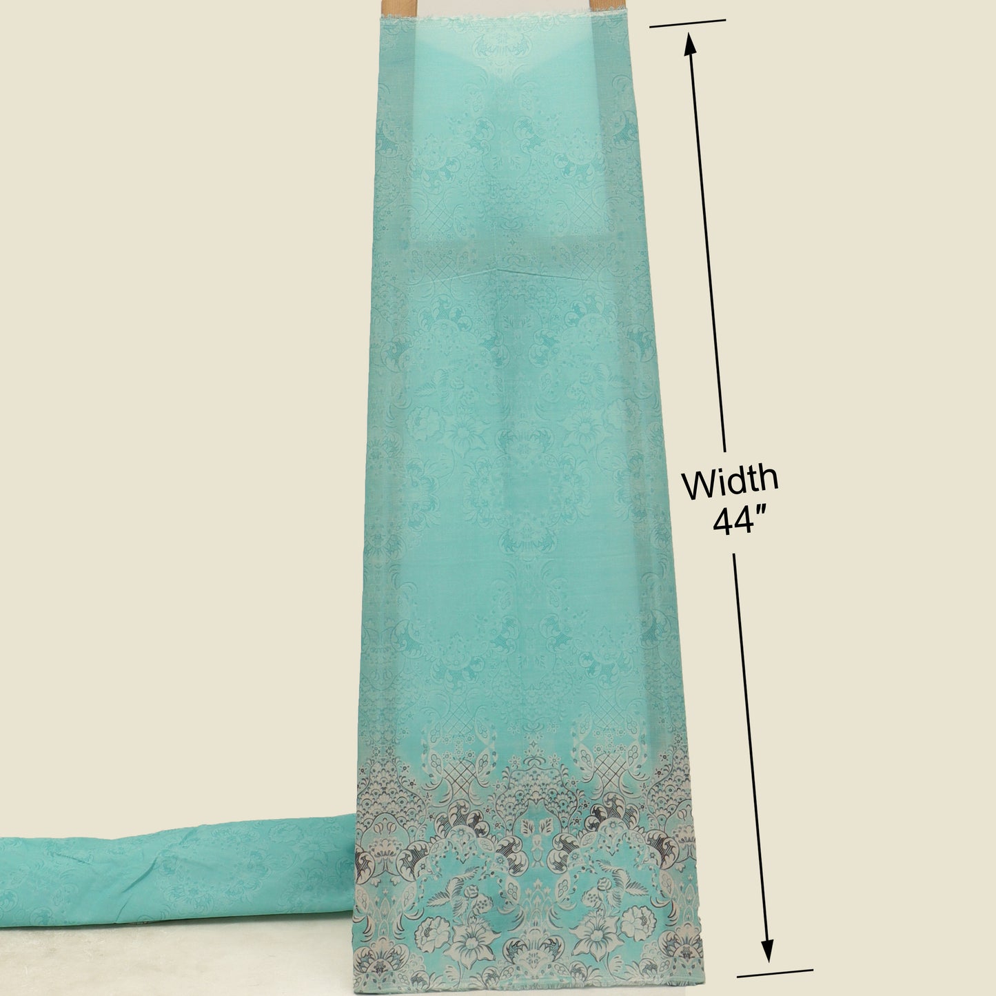 Turquoise fabric with decorative border and measurement label on a beige background