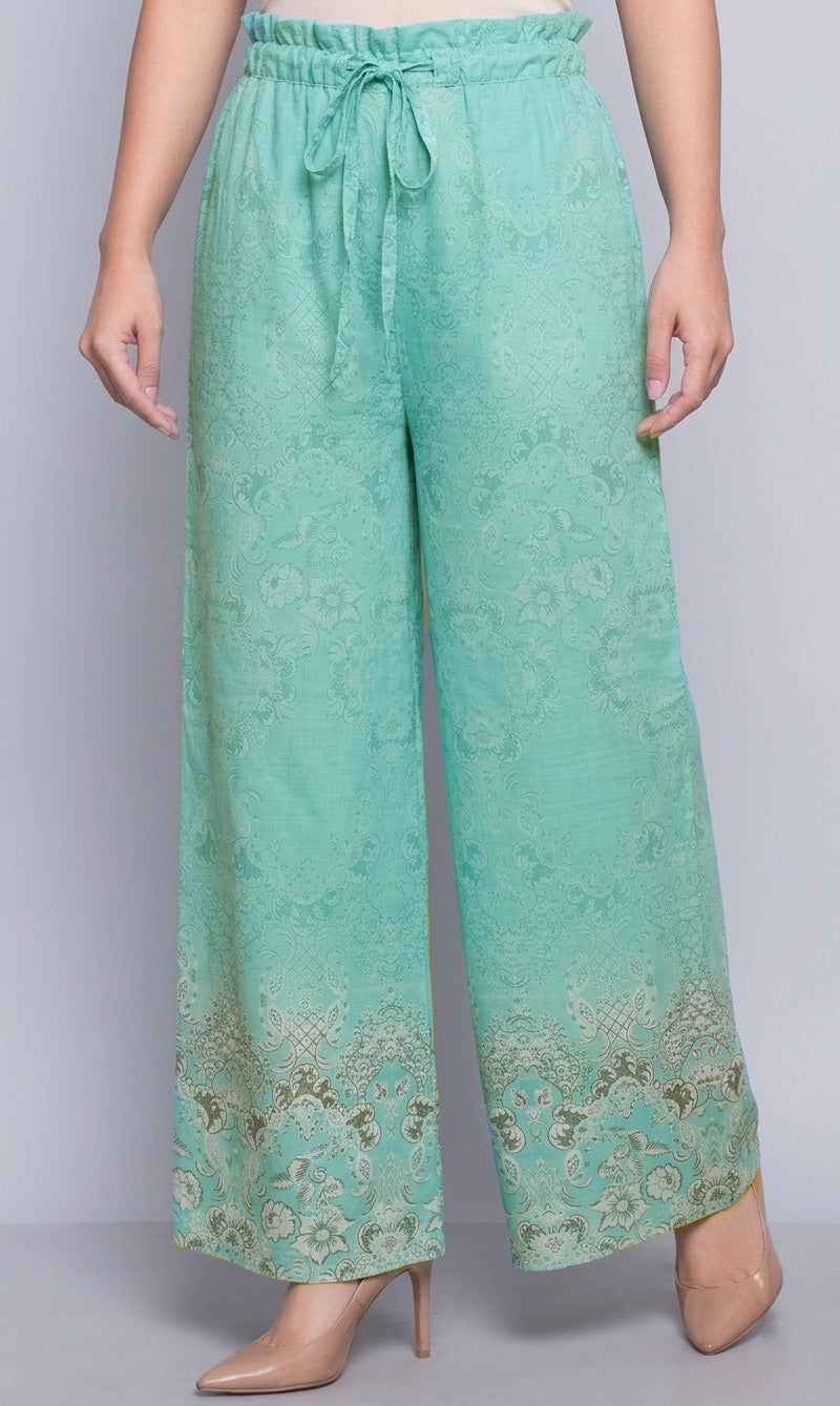 Teal patterned pants worn by a person on a plain background
