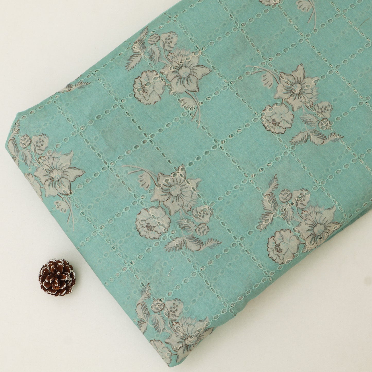 Teal quilt with floral pattern on a white background