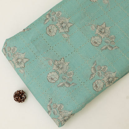 Teal quilt with floral pattern on a white background