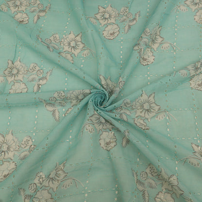 Teal fabric with floral pattern, folded in a way that creates a circular shape.