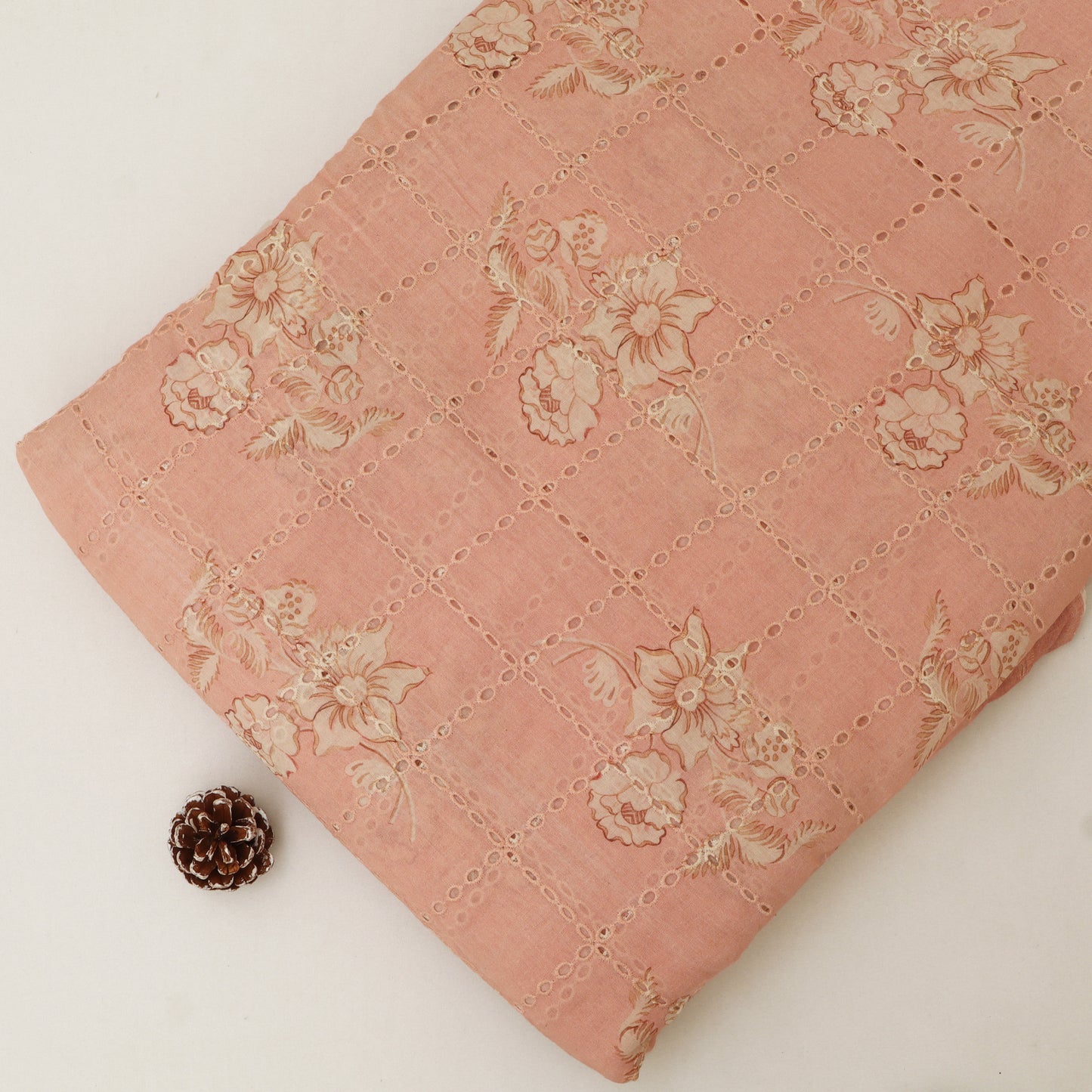 Pink quilt with floral patterns on a white background