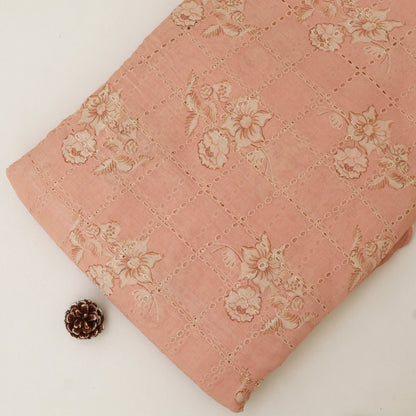 Pink quilt with floral patterns on a white background