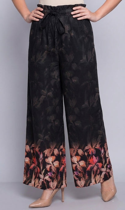 Floral patterned pants worn by a person on a plain background