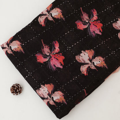 Floral-patterned fabric on a white background with a pine cone