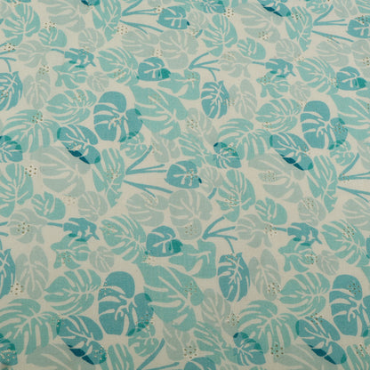 Patterned fabric with blue and green leaves on a light background