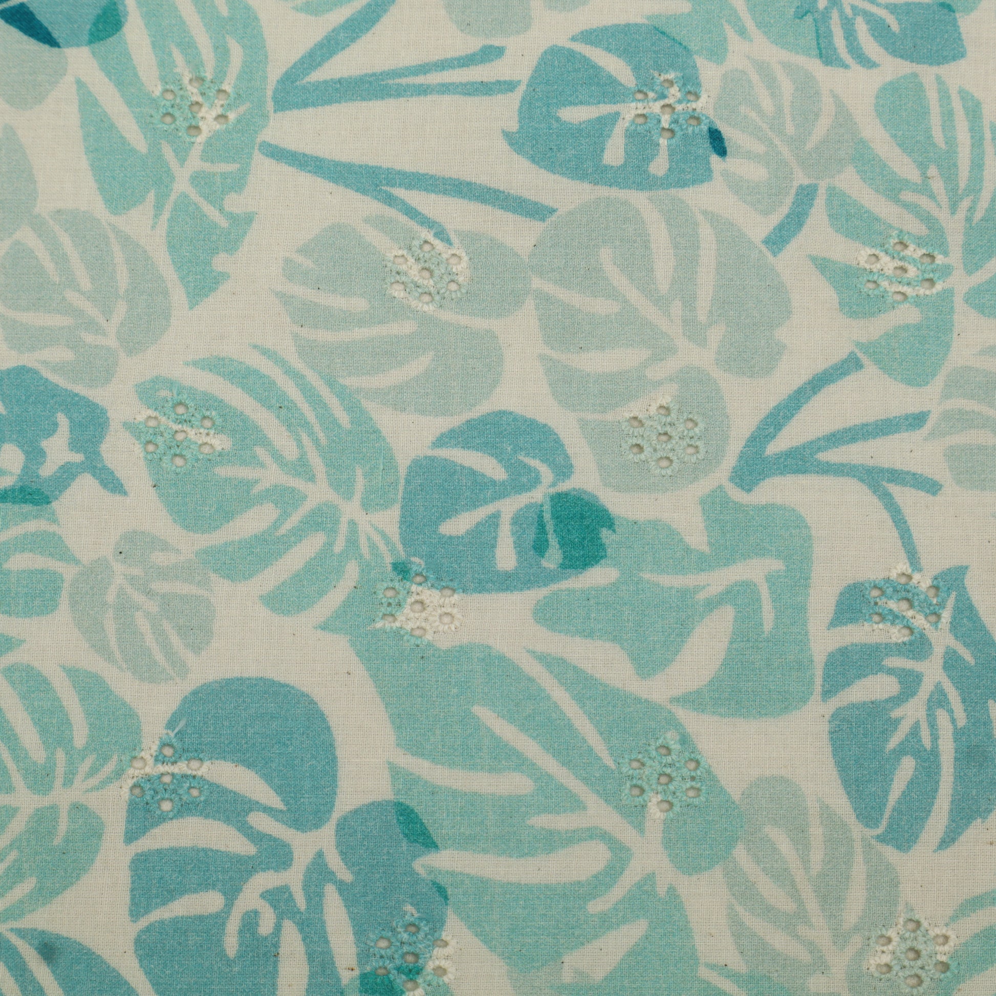 Patterned fabric with blue and green leaves on a beige background
