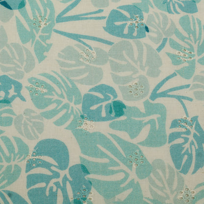 Patterned fabric with blue and green leaves on a beige background