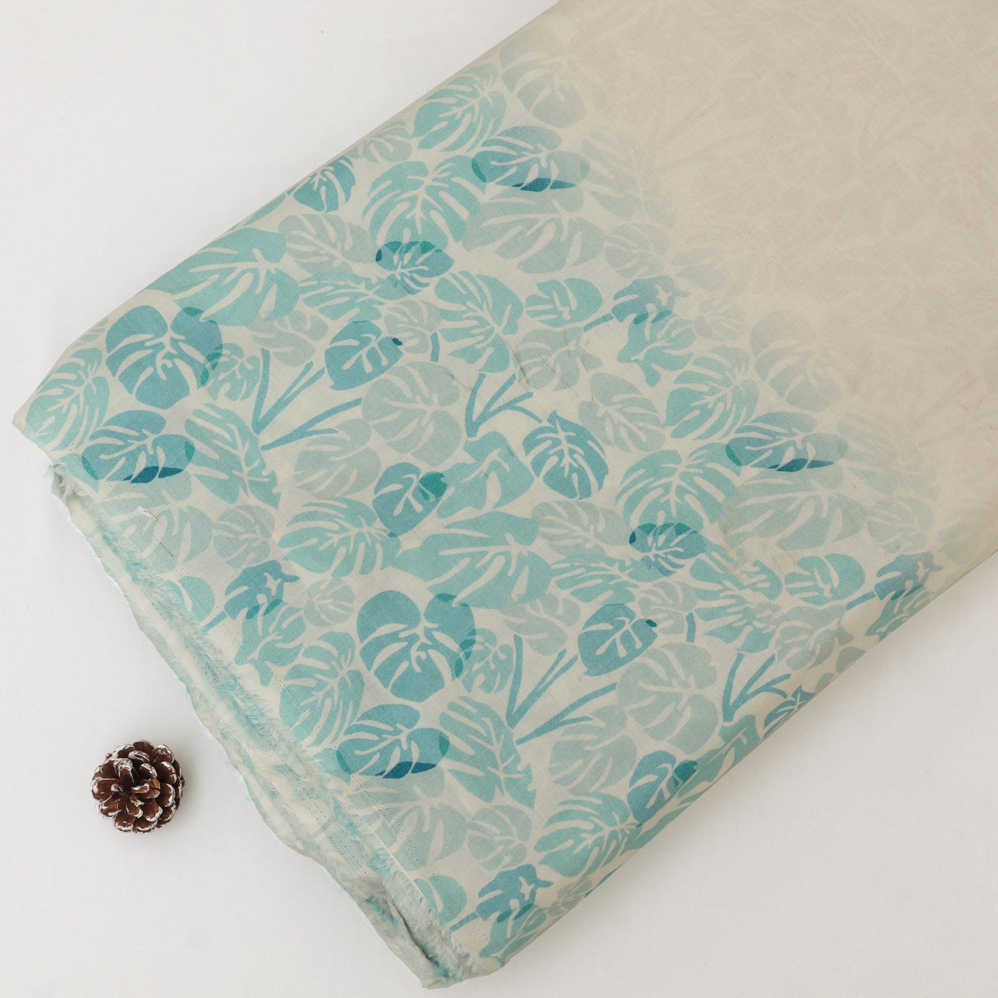 Fabric with teal leaf pattern on a white background