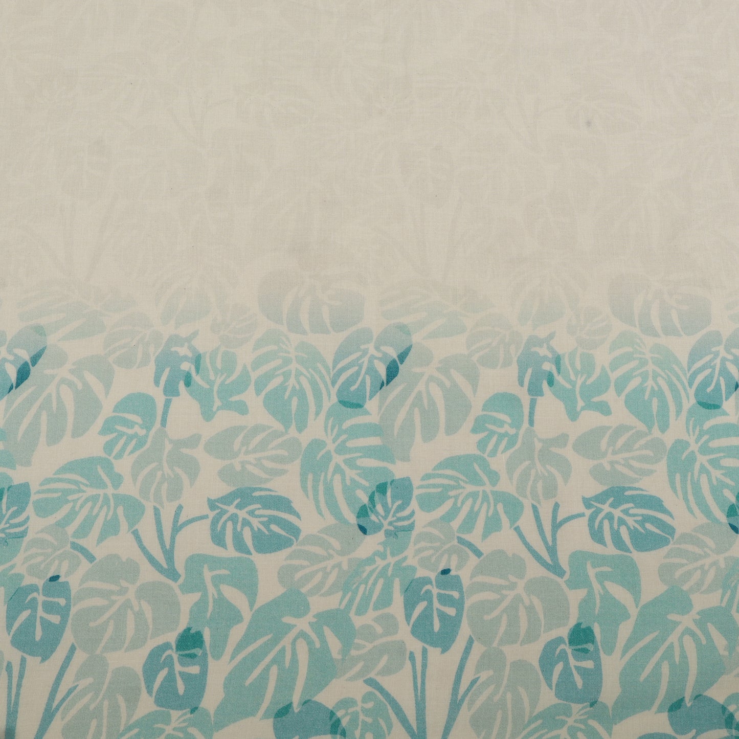 Patterned fabric with blue leaf design on a beige background
