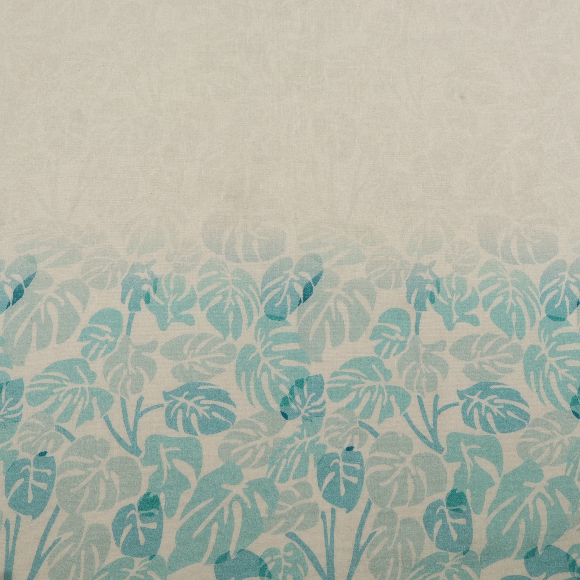 Patterned fabric with blue leaf design on a beige background