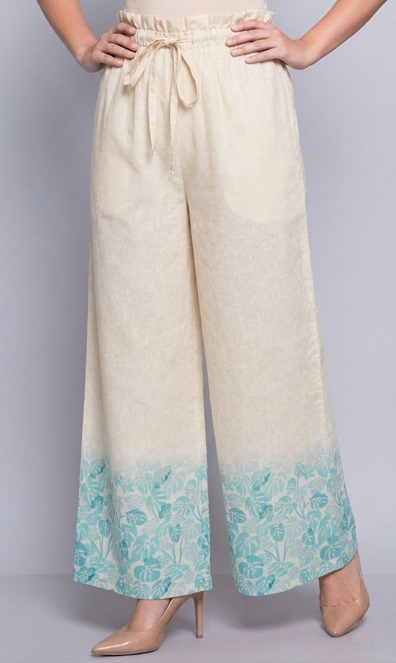 Beige pants with a blue floral pattern at the bottom on a gray background