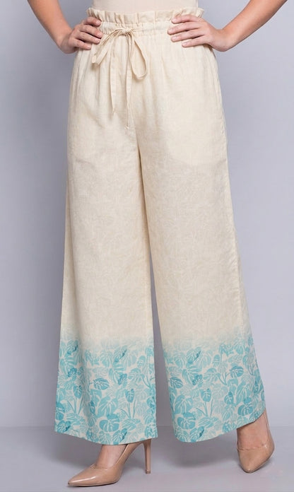 Beige pants with a blue floral pattern at the bottom on a gray background