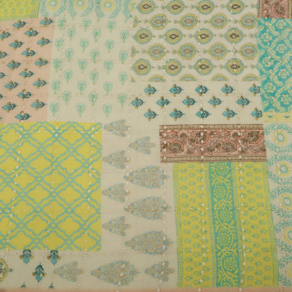 Patterned fabric with a patchwork of geometric and floral designs.