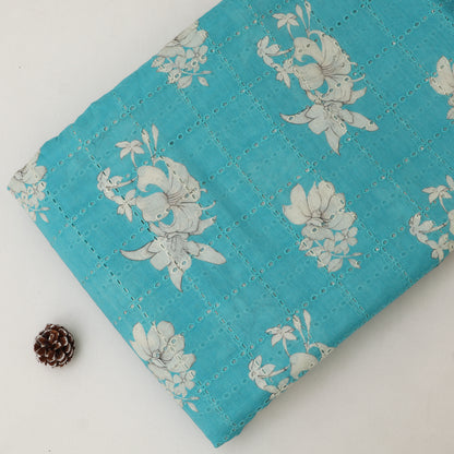 Turquoise quilt with floral patterns on a white background