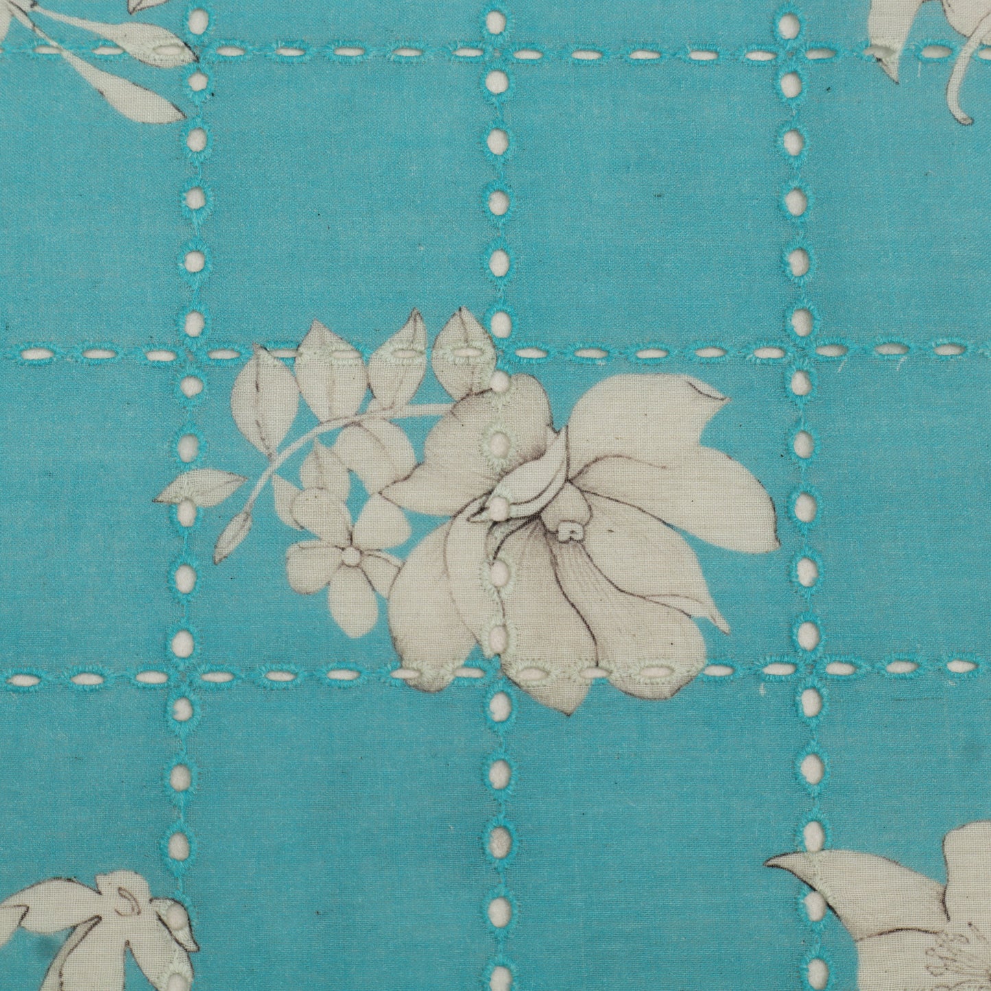 Floral pattern on a blue fabric with white stitching