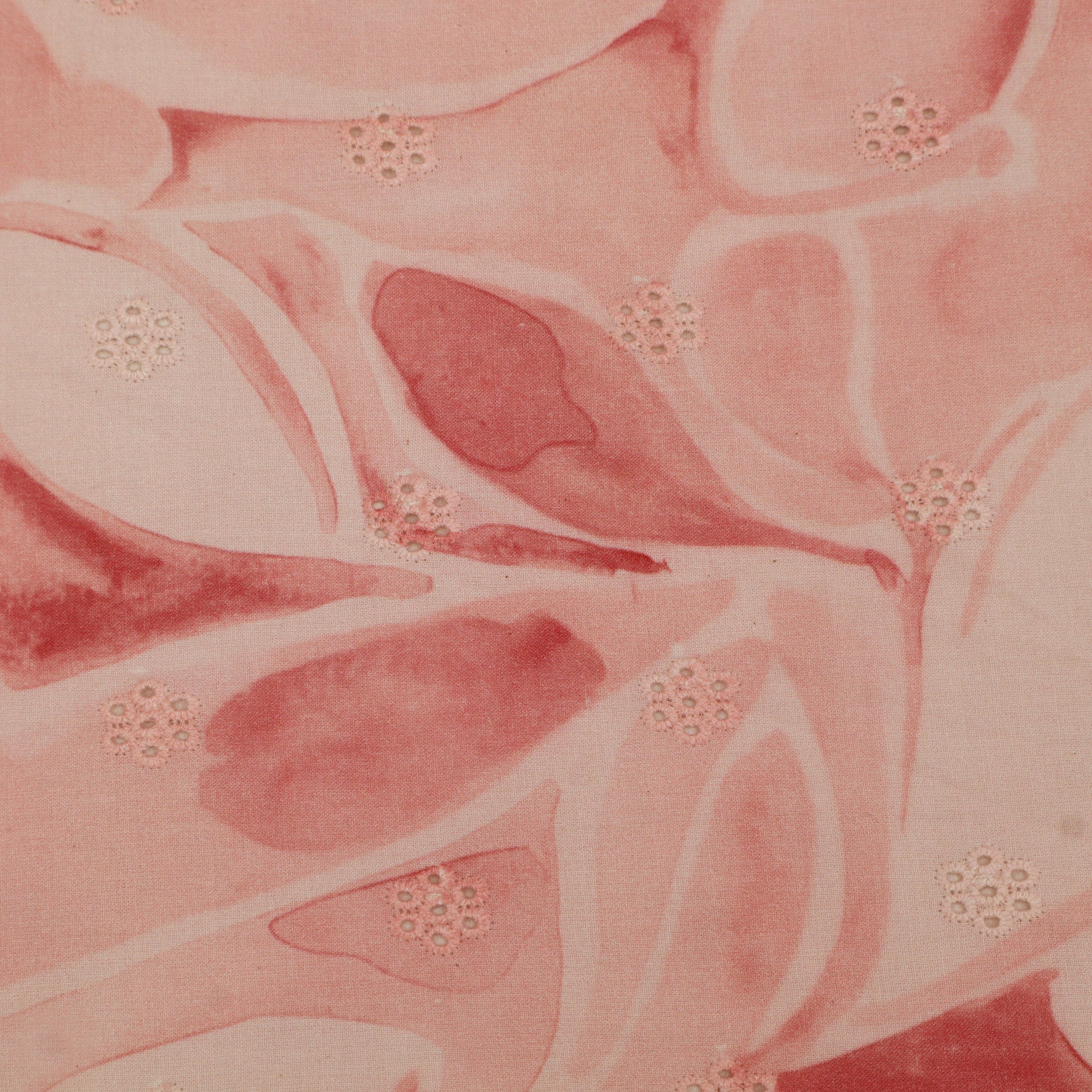 Close-up of pink fabric with floral patterns and embellishments