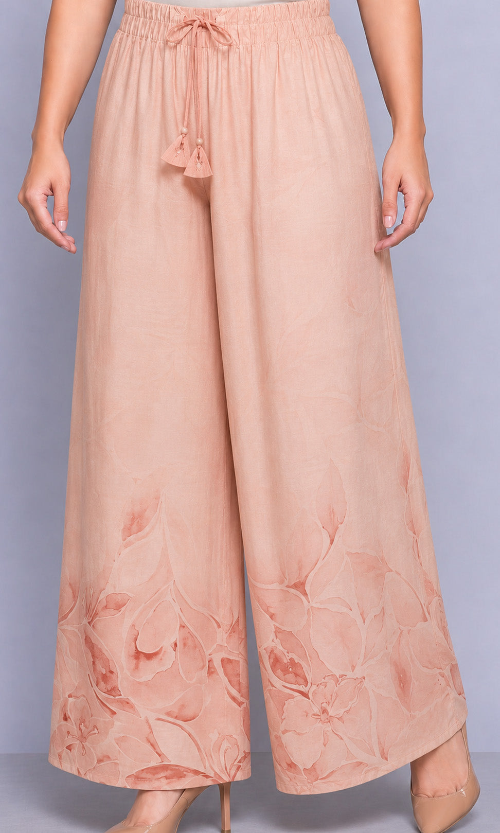 Pink floral pants worn by a person on a light gray background