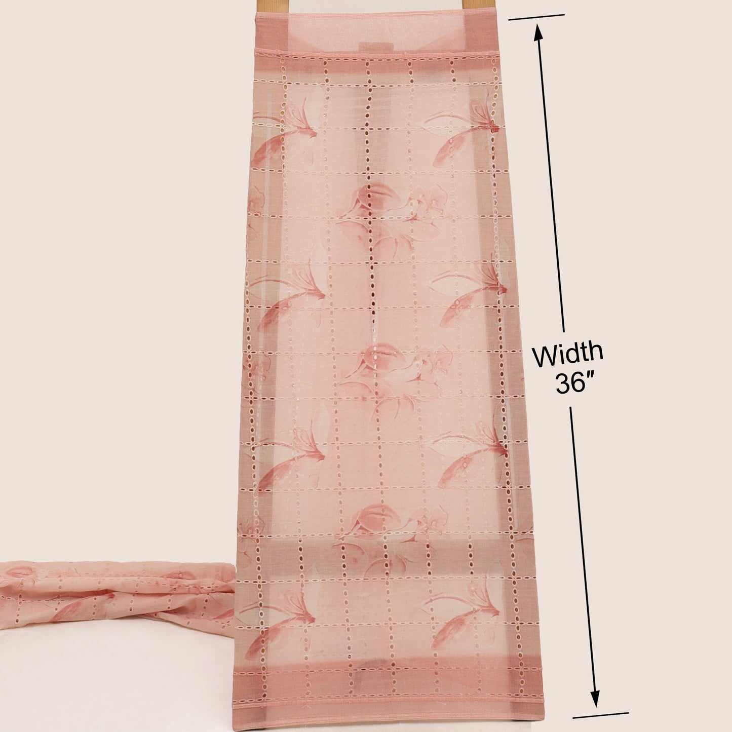 Pink floral patterned fabric with a measurement label on a beige background