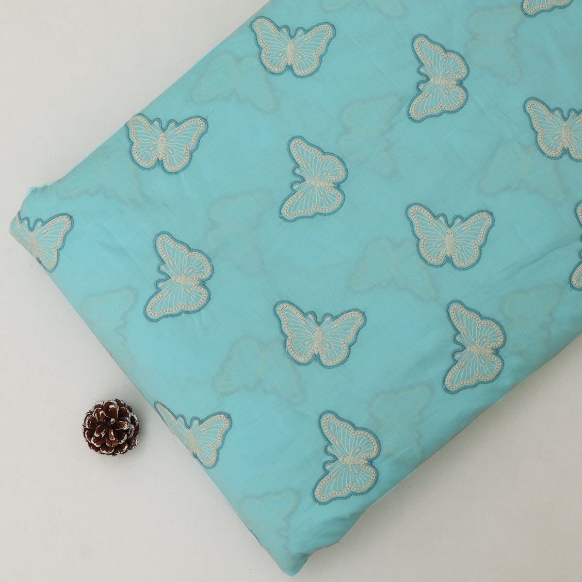 Turquoise fabric with butterfly patterns on a white background