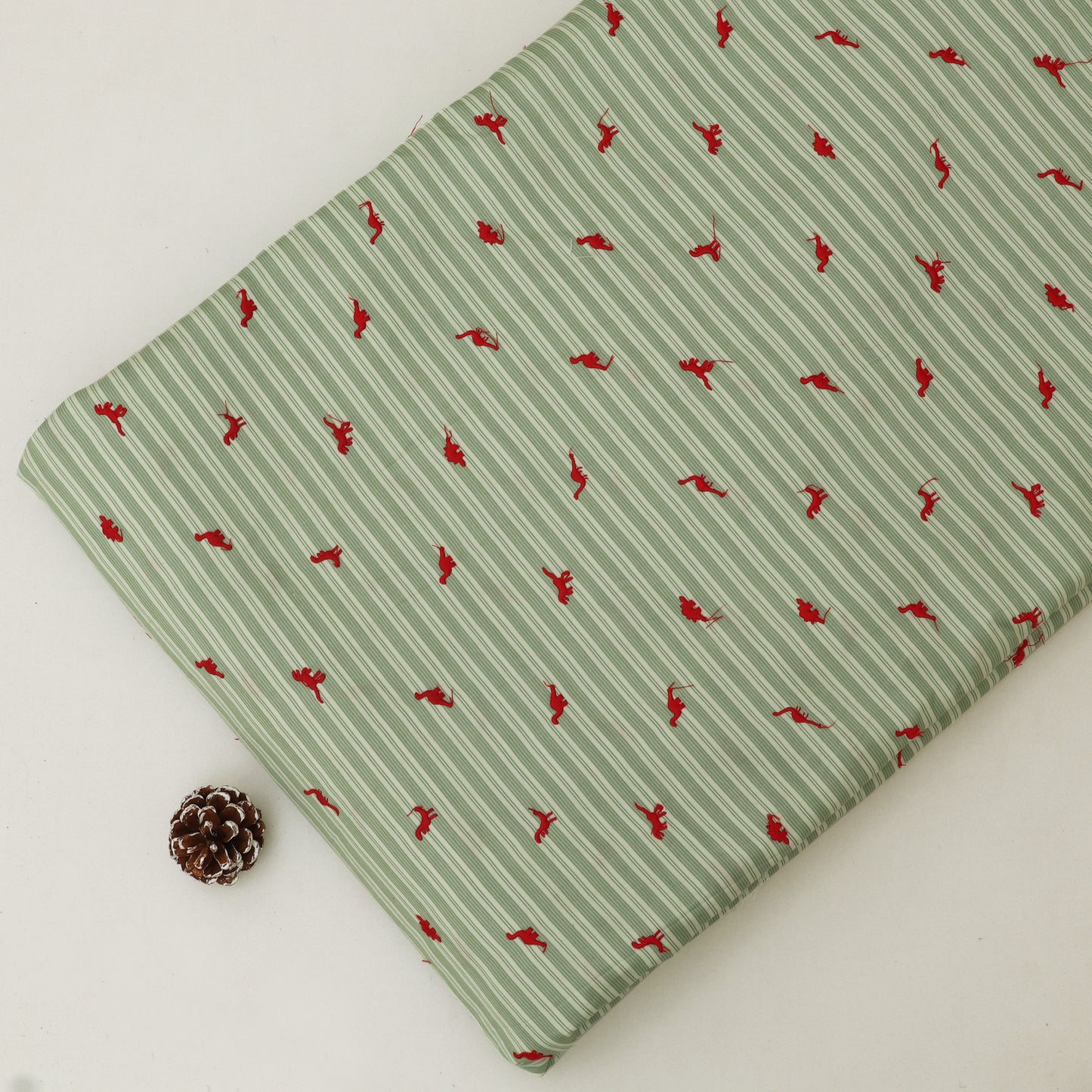Green fabric with red pattern on a white background