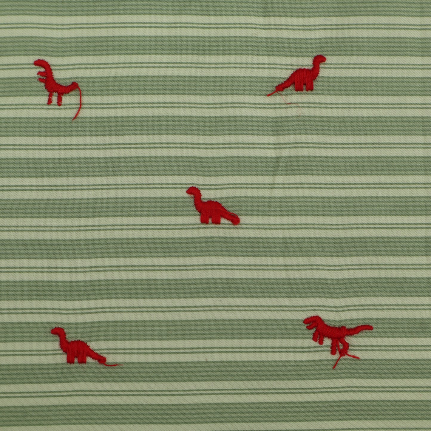 Green fabric with red dinosaur patterns