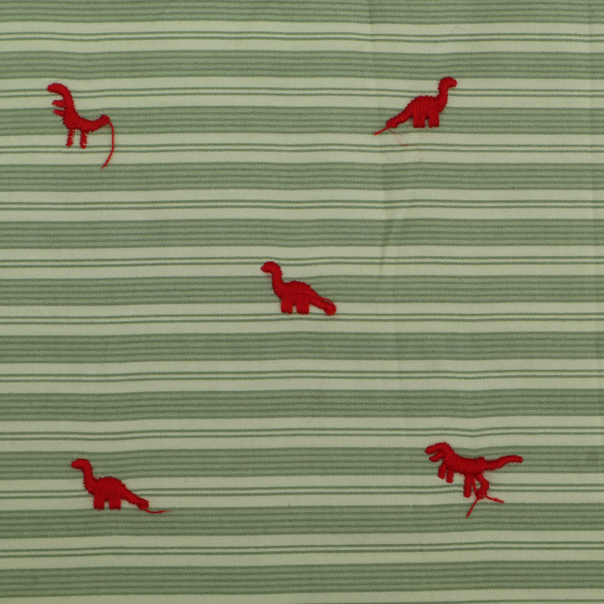 Green fabric with red dinosaur patterns