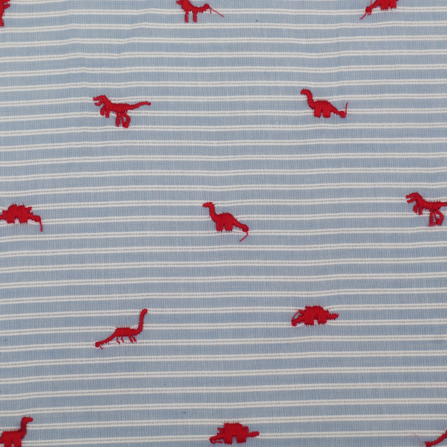 Fabric with red dinosaur patterns on a blue and white striped background